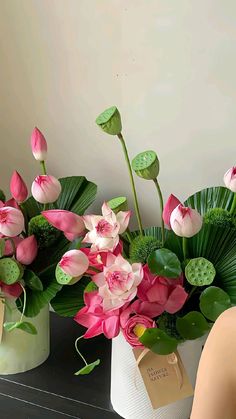 two vases with pink and white flowers in them