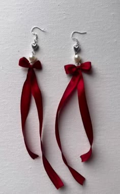 pair of red ribbon and pearl earrings on white background