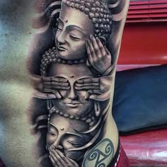 a man's back with a buddha tattoo on his stomach and hands holding the head of another person