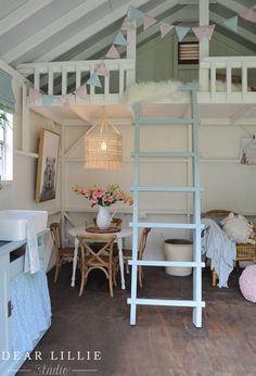 there is a loft bed with a ladder in the room and flowers on the table