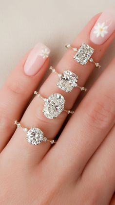 a woman's hand with three different rings on it, including one diamond and the other