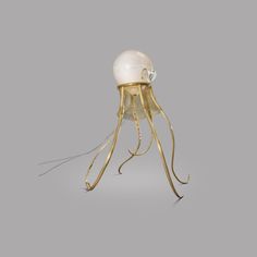 an octopus lamp with a glass ball on it's head and long tentacles attached to the base