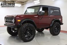 a red jeep is parked in a garage