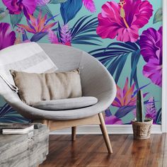 a chair with a pillow on it in front of a flower wallpapered room