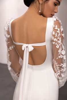 the back of a woman wearing a white dress