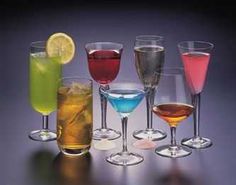 there are many different types of drinks in glasses on the table, all lined up and ready to be served