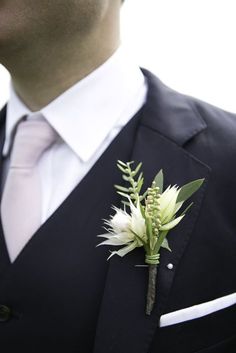 a man in a suit and tie with a boutonniere on his lapel