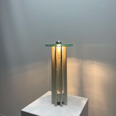 a table lamp sitting on top of a white pedestal