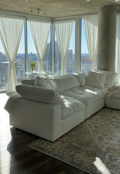 a large white couch sitting in front of a window