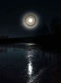 the moon is shining brightly in the dark sky over a body of water at night