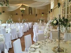 the banquet hall is set up with white linens and floral centerpieces for an elegant wedding