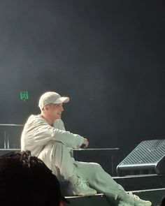 an older man sitting on top of a stage