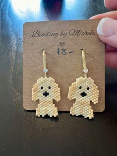 a pair of beaded earrings with a dog on it