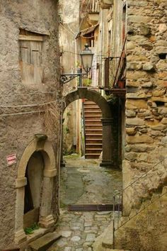 an alley way with stone buildings and stairs