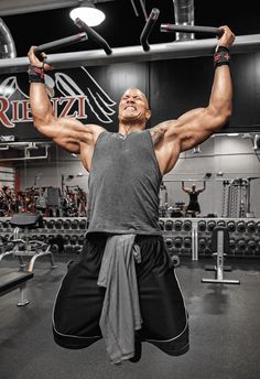 a man is lifting his arms in the gym