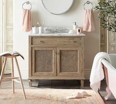 a bathroom with a sink, mirror and bathtub next to a rug on the floor