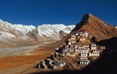 an old village in the mountains with snow on top