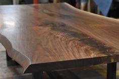 a wooden table with metal legs in a workshop area, close up view from the top