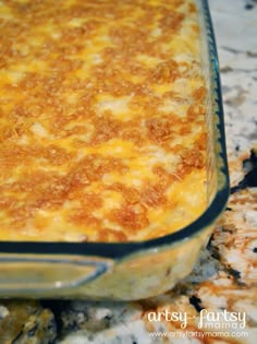 a casserole dish sitting on top of a counter next to some crackers