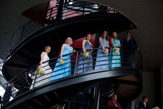 a group of women standing on top of a spiral staircase