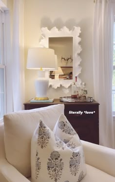 a living room with white furniture and pillows