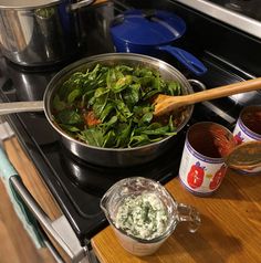 a pan filled with spinach and other ingredients on top of a stove