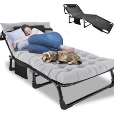 a woman laying on top of a bed with a cat sleeping on the mattress next to her