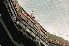 the outside of a building with many flags on it's roof and some buildings in the background