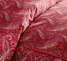 an image of a red paisley comforter with matching sheets and pillow cases on it