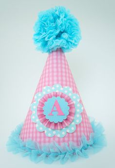 a pink and blue party hat with the letter a on it's centerpiece