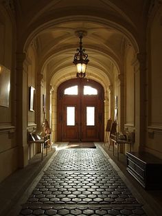 an empty hallway with a light hanging from the ceiling