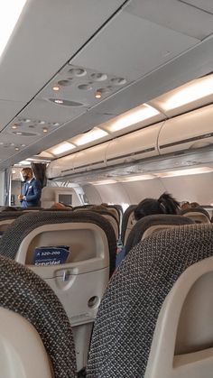 the inside of an airplane with people sitting on seats