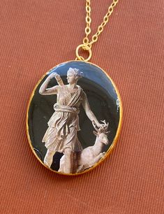 a necklace with an image of a statue and a dog