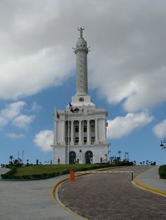 a tall white building with a clock on the top and a flag flying in the air