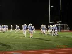 a football game is being played on the field at night with players in blue and white uniforms