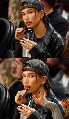 a woman eating something while sitting in a chair at a basketball game with other people watching