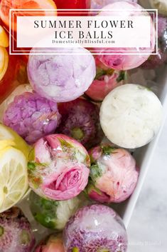 an assortment of different colored flowers in a white bowl on a marble counter top with water droplets over them