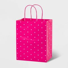 a pink shopping bag with white polka dots