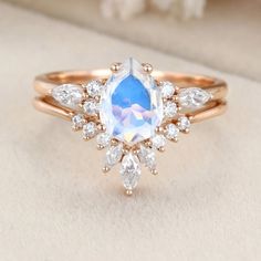 an engagement ring with a blue topazte surrounded by white and clear diamonds on a beige background