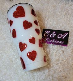 a white cup with red hearts on it and a tag that says e & g fashions