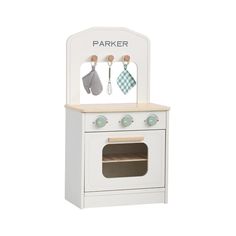 a white wooden play kitchen with oven and utensils on the top, in front of a white background