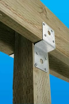 a close up of a wooden post with metal brackets on the top and bottom part