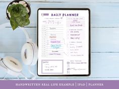 the daily planner is next to headphones and a plant