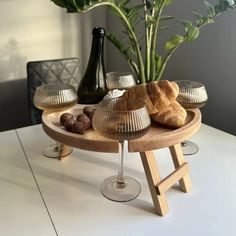 there is a tray with bread and wine on the table next to two vases