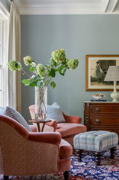 a living room filled with furniture and flowers in a vase on top of a table