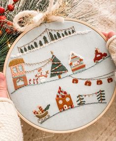 someone is holding up a cross stitch christmas ornament