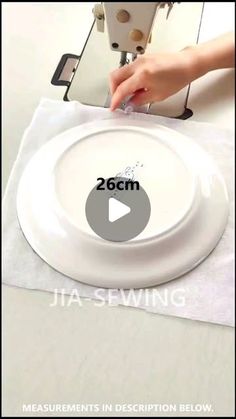 someone is sewing on a white plate with the words 2 6cm in front of it