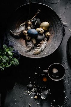 an assortment of eggs in a black bowl on a table by jovo studio for stocks & bond