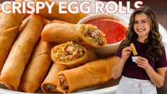 a woman standing in front of a white plate filled with egg rolls and dipping sauce