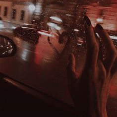 a person's hand on the dashboard of a car in the rain at night